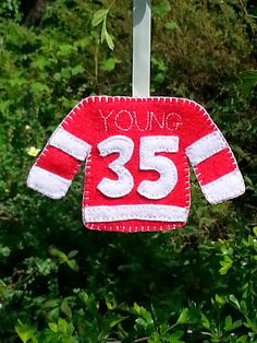 a red and white knitted sweater hanging from a clothes line with the number 35 on it