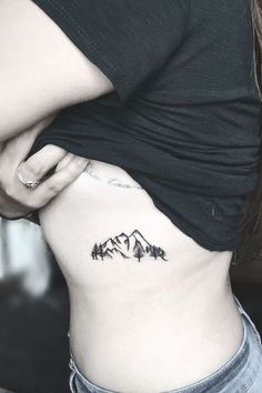 a woman with a mountain tattoo on her stomach