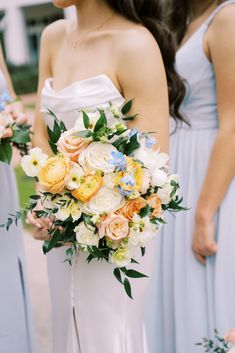 the bridesmaids are holding their bouquets in blue and yellow colors, including roses