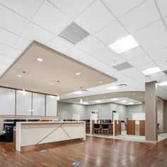 an empty office with hard wood flooring and white walls, large windows on the ceiling