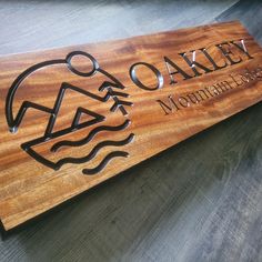 a wooden sign that says oaky mountain lodge on it's side with an image of a man swimming in the water