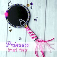 a mirror that is sitting on top of a wooden table with beads and pink ribbon