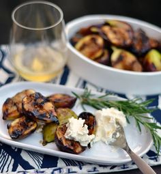 grilled vegetables and mashed potatoes on a plate next to a glass of wine