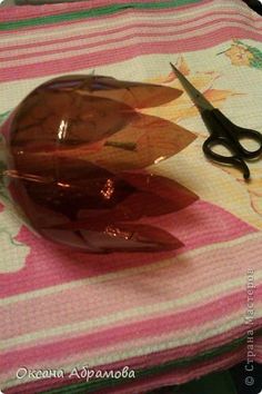 a pair of scissors sitting on top of a pink and white table cloth next to a brown vase