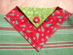 a close up of a red and green shirt with christmas trees on the collaring