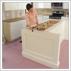 a woman standing at the top of a kitchen island