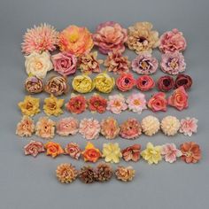 a bunch of flowers that are sitting on a table together, all in different colors and sizes