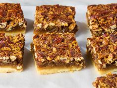 six pieces of pecan bar sitting on top of a white paper towel next to each other