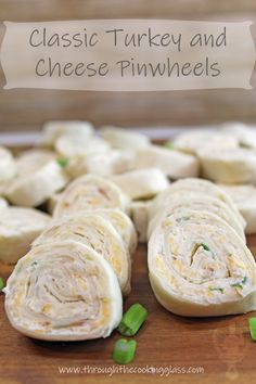 a wooden cutting board topped with sliced up cheese pinwheels