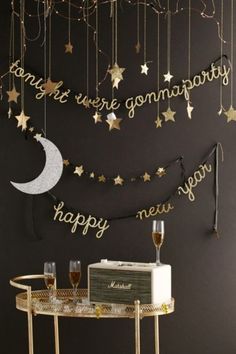 a black wall with gold stars and a white cake on the table next to it