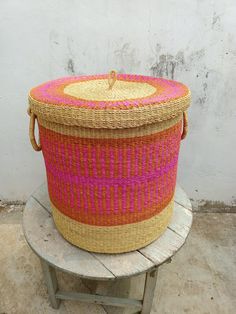 a woven basket sitting on top of a wooden table next to a white brick wall