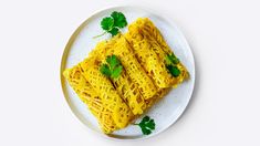 some noodles on a white plate with parsley