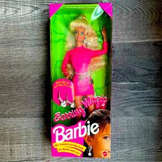 the barbie doll is in its box on the wooden floor next to it's packaging