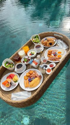 a boat filled with lots of food sitting on top of a body of blue water