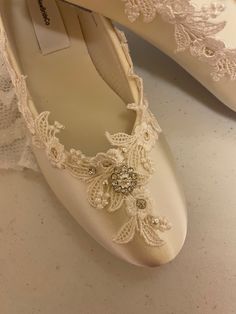 wedding shoes with lace and beading on the bottom are ready to be put on