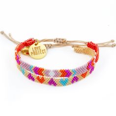 the multicolored beaded bracelet has a gold plated charm that reads, peace