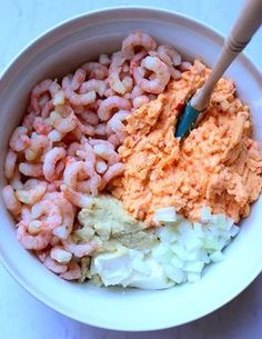 a bowl filled with shrimp and coleslaw on top of a white countertop