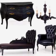 an assortment of black furniture including a chair, armoire and footstool with candles