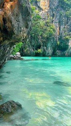 the water is crystal blue and green in this photo, with some rocks on either side