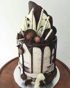 there is a chocolate cake with white frosting on the top and decorations around it