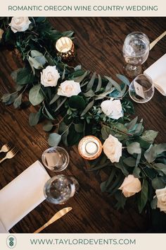 the table is set with candles, flowers and greenery