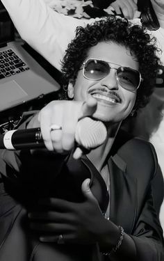 a man wearing sunglasses and holding a microphone