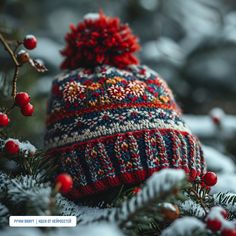 a knitted hat sitting on top of a tree covered in snow and pine needles