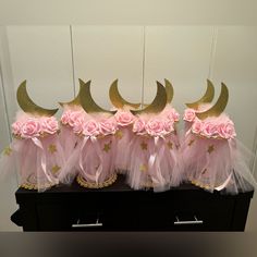 three pink tulle skirts with gold stars and roses on them, sitting next to each other