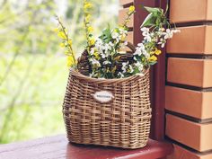 a basket filled with flowers sitting on top of a window sill