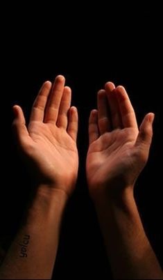 two hands reaching up into the air with their palms raised in front of them, against a black background