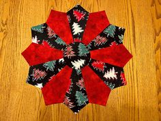 a red and black christmas ornament sitting on top of a wooden table