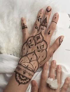 two hands with henna tattoos on them