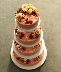 a three tiered cake sitting on top of a white plate covered in frosting