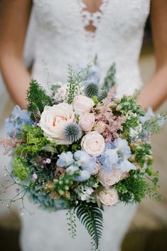 a bridal holding a bouquet of flowers and greenery