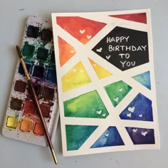 a watercolor card with the words happy birthday to you on it next to a paint palette