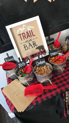 a table topped with lots of food next to a sign that says trail mix bar