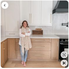 a woman standing in a kitchen with her arms crossed