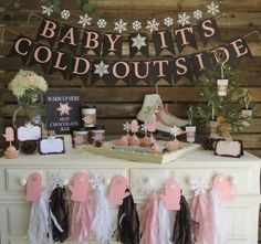 a baby it's cold outside party with pink and black decorations on the mantle