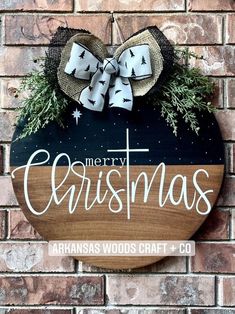 a wooden sign hanging on the side of a brick wall with a bow and christmas decoration