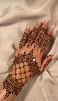 a woman's hand with henna tattoos on it