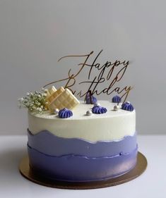 a blue and white birthday cake with the words happy birthday on it's top