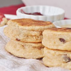 some biscuits are stacked on top of each other next to a bowl of jelly and strawberry jam