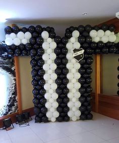 an inflatable balloon letter that is black and white with some white balloons on it