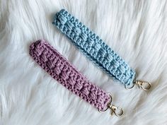 two crocheted key fobs laying on top of a white furry surface