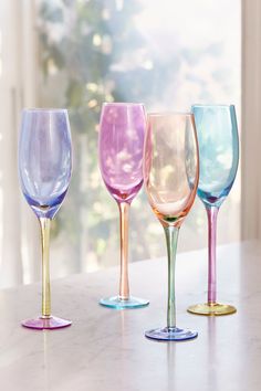 four different colored wine glasses sitting on a table