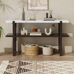 a white and brown table sitting on top of a wooden floor next to a potted plant