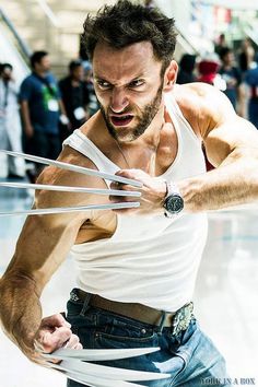 a man in white shirt and jeans holding two large scissors