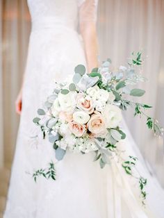 a bridal holding a bouquet of flowers and greenery