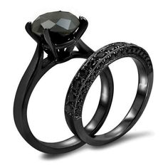 two black gold wedding rings with diamonds on each side and an oval cut diamond in the center