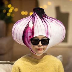 a woman wearing sunglasses and a large onion hat on top of her head in front of a couch